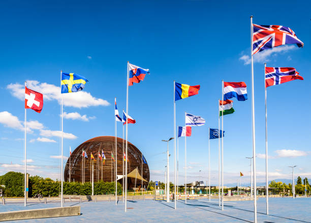 The Globe of Science and Innovation at CERN near Geneva. Meyrin, Switzerland - September 7, 2020: The Globe of Science and Innovation at CERN, the European Center for Nuclear Research, with the flags of the member states flying against blue sky. large hadron collider stock pictures, royalty-free photos & images