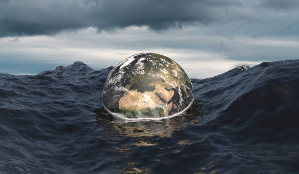 The globe sinks into the ocean as symbol for rising sea level because of global warming and pollution. Stormy ocean and dramatic sky. Global warming, climate change concept created with Blender. 3D illustration, 3D Render. 
The image of the earth map is provided by NASA https://visibleearth.nasa.gov. (Collection of Maps https://visibleearth.nasa.gov/collection/1484/blue-marble) climate action stock pictures, royalty-free photos & images