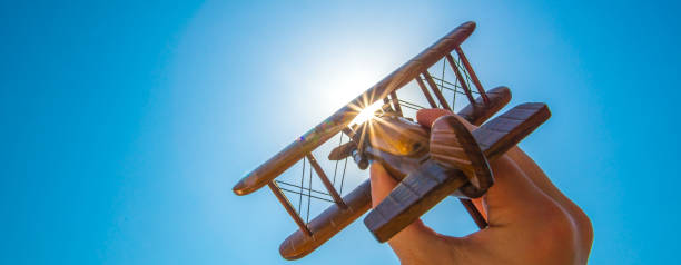 The hand launch a wood plane on the background of the sun stock photo