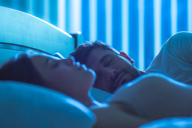 The handsome man sleeping near the woman in the bed. night time stock photo