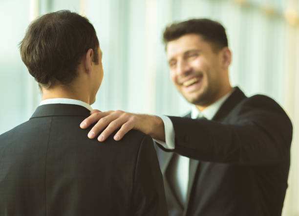 The happy businessmen pat on the shoulder in the office stock photo