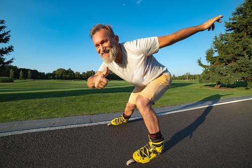 The Happy Old Man Rollerblading And Thumbs Up On The Alley Stock Photo ...