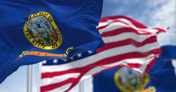 The Idaho state flag waving along with the national flag of the United States of America stock photo