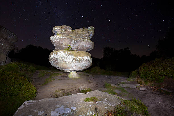 The Idol - Brimham Rocks at Night The Brimham Rocks are balancing rock formations located on Brimham Moor in North Yorkshire, England. The rocks stand at a height of nearly 30 metres in an area owned by the National Trust which is part of the Nidderdale Area of Outstanding Natural Beauty. brimham rocks stock pictures, royalty-free photos & images