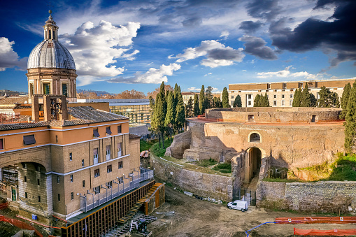 A view of the remains of the imposing mausoleum of Augustus, also known as Augusteo, the iconic funerary monument of Emperor Augustus which will reopen to the public in March 2021 after a 12-year restoration. The mausoleum, built starting from 28 BC. it stood in the northern part of the Campo Marzio and was one of the wonders of imperial Rome. A few meters away is the Ara Pacis, the altar dedicated to peace erected by Augustus in the year 9 BC. On the left the church and the convent of San Rocco all'Agusteo. Image in high definition format.