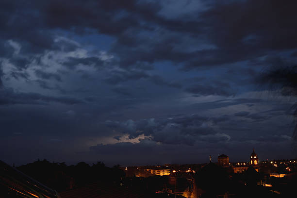 the indigo blue sky over the city - bewolkt stockfoto's en -beelden