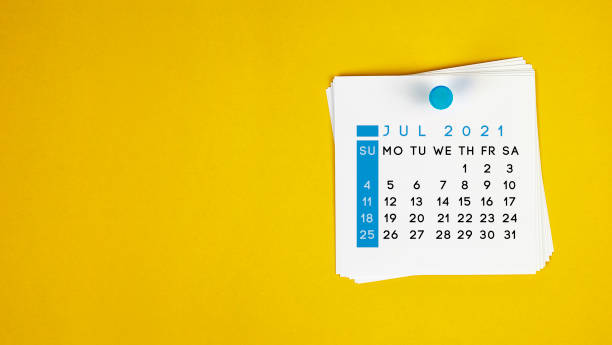 The July 2021 calendar is pinned on a yellow background. The July 2021 calendar is pinned on a yellow background. Horizontal composition with copy space. july stock pictures, royalty-free photos & images