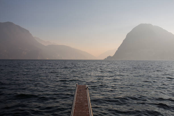 The lake of Lugano with misty sky and mountains at the distance stock photo