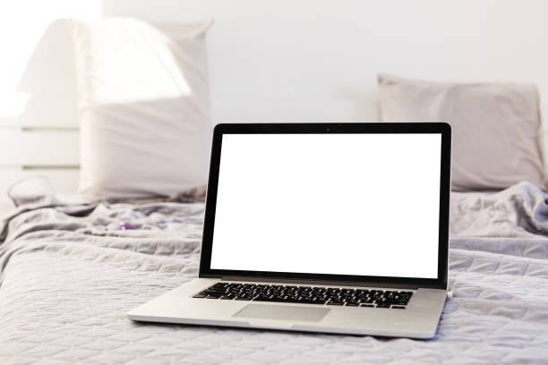 The laptop and computer in the morning on a white pillow bed. Lifestyle Concept stock photo