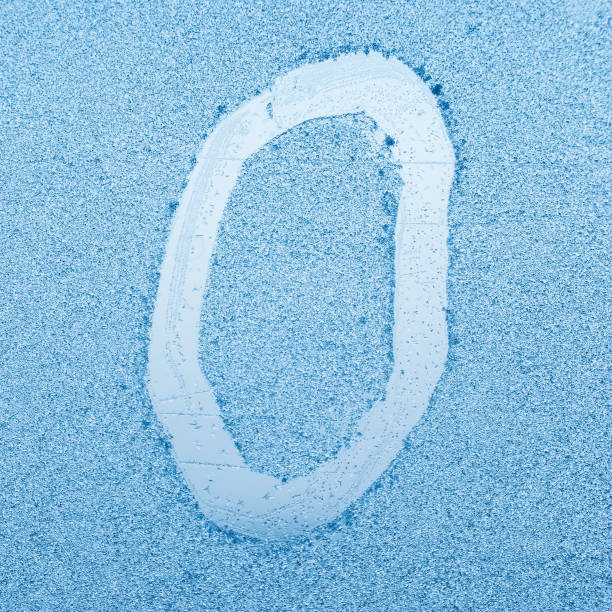 The letter O written on glass with frost in the frost in winter, close up stock photo