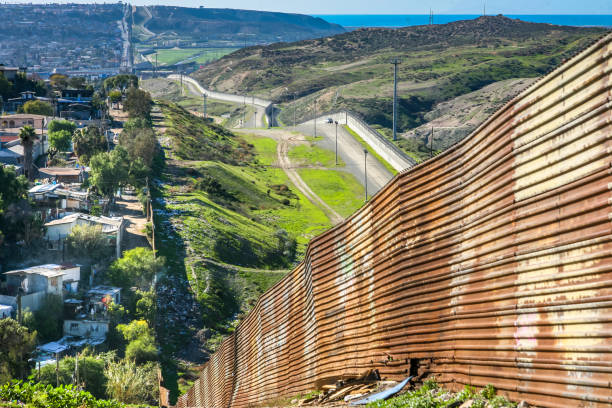 длинная и деградировавая железная стена на границе сша и мексики в тихуане на севере мексики - tijuana стоковые фото и изображения