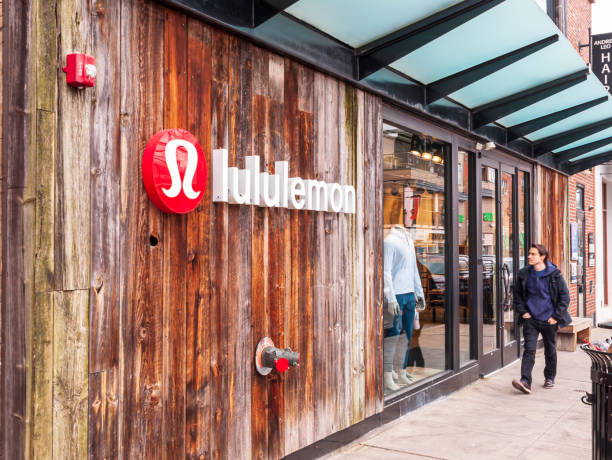 The Lululemon store on Walnut street in the Shadyside neighborhood with a man walking in front of it, Pittsburgh, Pennsylvania, USA stock photo
