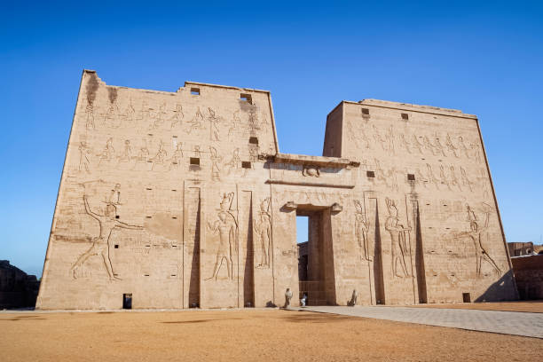 The main entrance of Edfu Temple showing the first pylon located on the west bank of the Nile in Edfu , Upper Egypt. stock photo