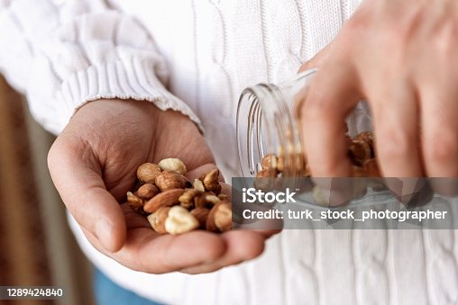istock The man is holding a jar of walnuts hazelnuts and almonds 1289424840