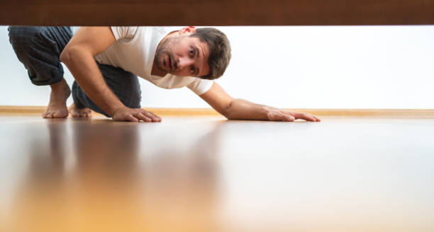 The man looking under the bed The man looking under the bed below stock pictures, royalty-free photos & images