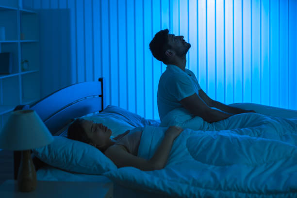 The man sit on the bed with an insomnia near woman. night time stock photo