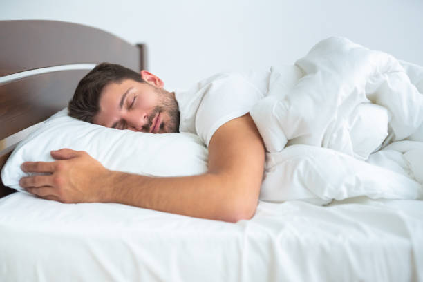 The man sleeping on the bed on the white background