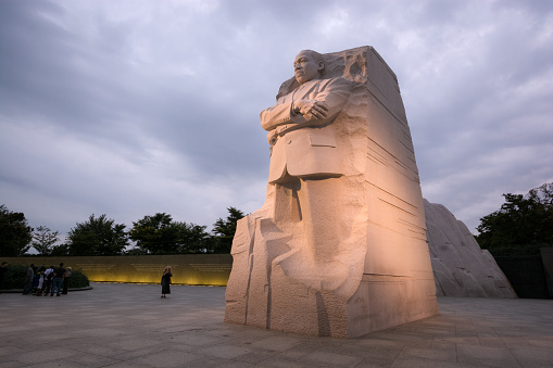 Washington, United States - August 18, 2014: People meander about the Martin Luther King, Jr. Memorial in West Potomac Park, southwest of the National Mall, during the nighttime. The memorial honors civil rights leader Martin Luther King, Jr. (1929-1968) and was sculpted by Chinese sculptor Lei Yixin (born 1954).