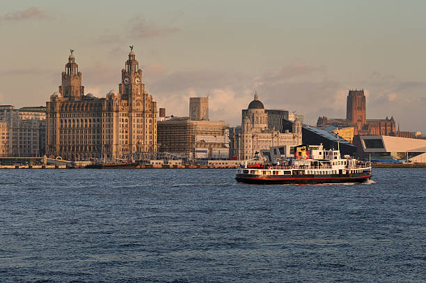 The Mersey Ferry The Ferry across the Mersey and the Liverpool Skyline bathed in the last rays of the setting sun. pierhead liverpool stock pictures, royalty-free photos & images