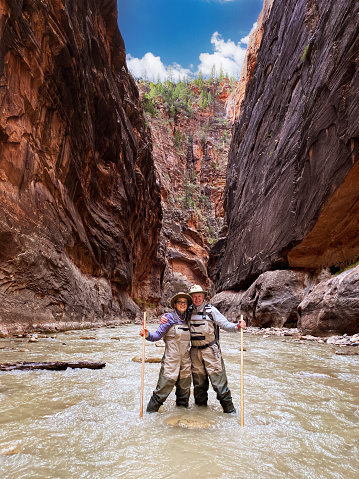 Self-portrait of senior couple in The Narrows and Virgin River in Zion National Park.