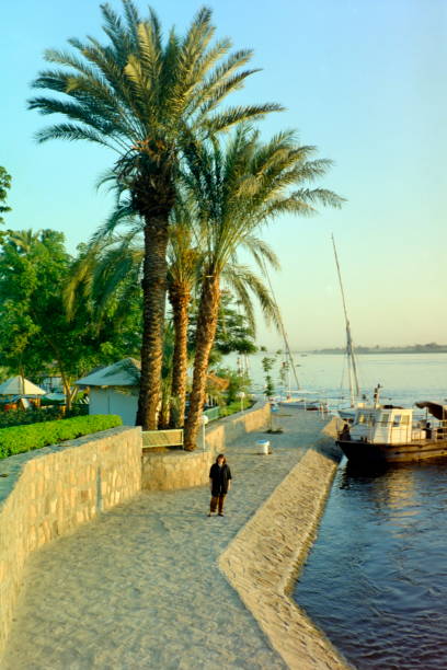 The nineties. A  Tourist enjoys a walk at the edge of the Nile river. Luxor, Upper Egypt. stock photo