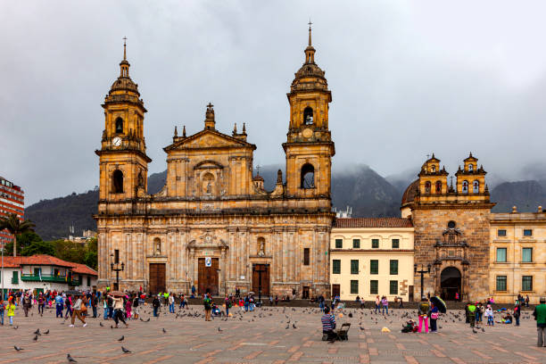 la catedral primada del siglo nteenés, sede del arzobispo católico de colombia, ubicada en la plaza bolívar contra un cielo nublado, en la capital andina. - plaza de bolívar bogotá fotografías e imágenes de stock