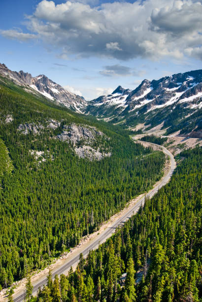 North Cascades Highway from Washington Pass The North Cascades Highway traverses the Cascade Range of mountains in an east-west direction. Only open late spring through fall, this highway offers stunning views and access into the North Cascades National Park. This winding highway scene was taken from the Washington Pass Overlook in the Okanogan National Forest, Washington State, USA. jeff goulden north cascades national park stock pictures, royalty-free photos & images