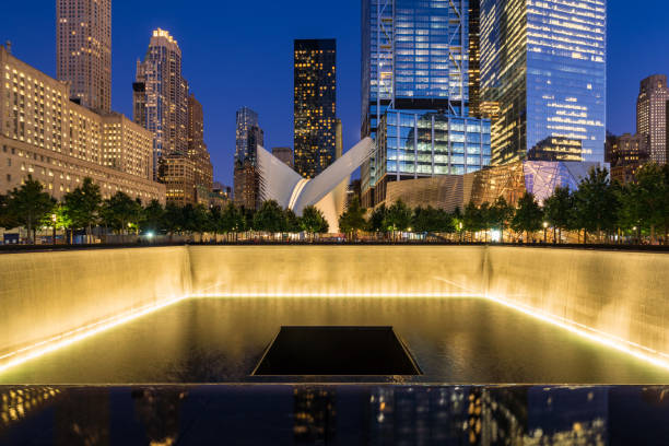 The North Reflecting Pool illuminated at twilight with view of the World Trade Center Tower 3 and 4 and the Oculus. Lower Manhattan, 9/11 Memorial & Museum. New York City New York City, NY, USA - October 10, 2017: The North Reflecting Pool illuminated at twilight with view of the World Trade Center Tower 3 and 4 and the Oculus. Lower Manhattan, 9/11 Memorial & Museum 911 memorial stock pictures, royalty-free photos & images