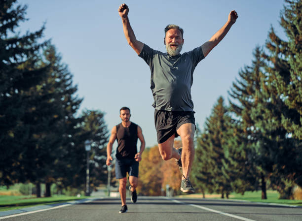 The old and young sportsmen running on the road stock photo