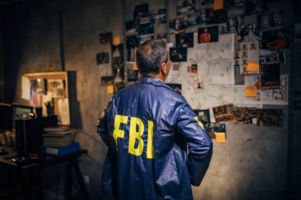 오래된 형사는 자신의 사무실에서 늦은 밤에 혼자 작동 - fbi 뉴스 사진 이미지