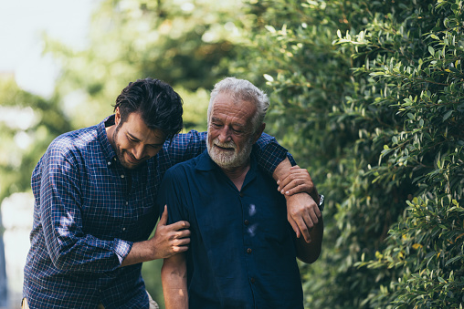 The Old Man And His Son Are Walking In The Park A Man Hugs His Elderly  Father They Are Happy And Smiling Stock Photo - Download Image Now - iStock