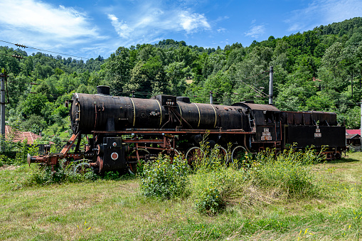 ​ Petrosani, Hunedoara, Romania –  July 11, 2021: The old steam locomotive is parked in a depot in Petrosani, Romania