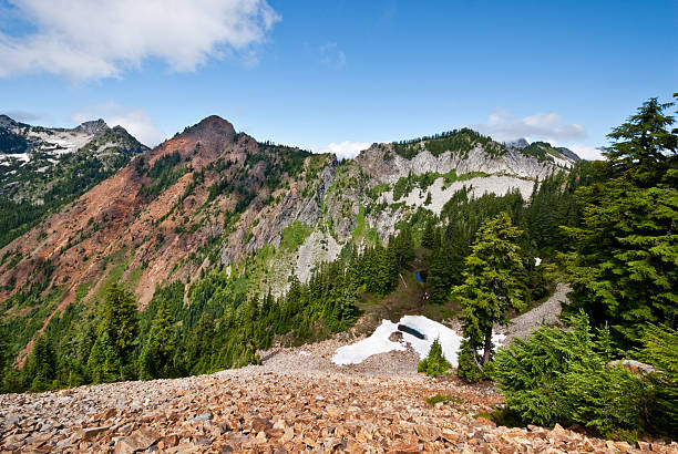 Red Mountain from the Pacific Crest The Pacific Crest Trail, officially known as the Pacific Crest National Scenic Trail, stretches 2,653 miles from the Mexican border to the Canadian Border. It follows the Cascade Range of mountains in Washington, Oregon and Northern California. In Southern California it follows the Sierra Nevada range. The mountains, lakes, meadows and forests along the Pacific Crest Trail are a visual delight in any season. This scene of Red Mountain was photographed from the high narrow Kendall Katwalk north of Snoqualmie Pass in the Alpine Lakes Wilderness, Washington State, USA. jeff goulden alpine lakes wilderness stock pictures, royalty-free photos & images