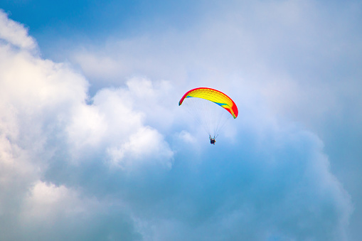 The paraglider flies in the sky in beautiful clouds