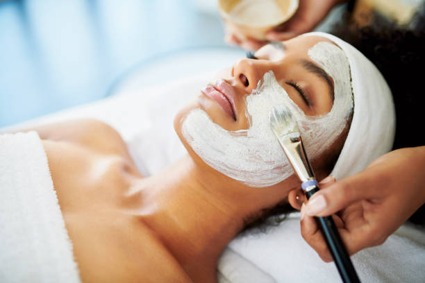 The perfect pick me up for her skin Shot of an attractive young woman getting a facial at a beauty spa applying photos stock pictures, royalty-free photos & images
