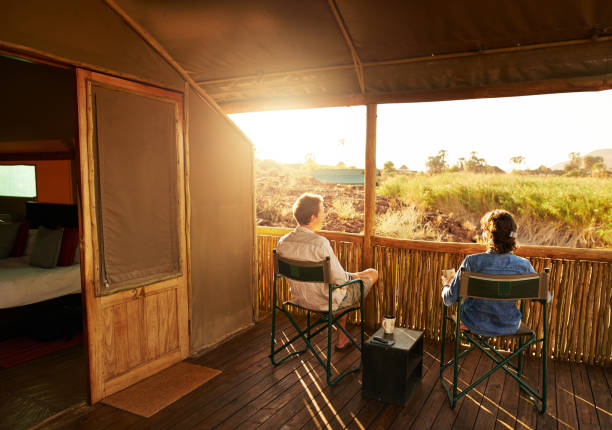 The perfect spot to look at the sunset Rearview shot of an unrecognizable couple looking at the view while sitting on their suites veranda at a resort in nature southern africa stock pictures, royalty-free photos & images