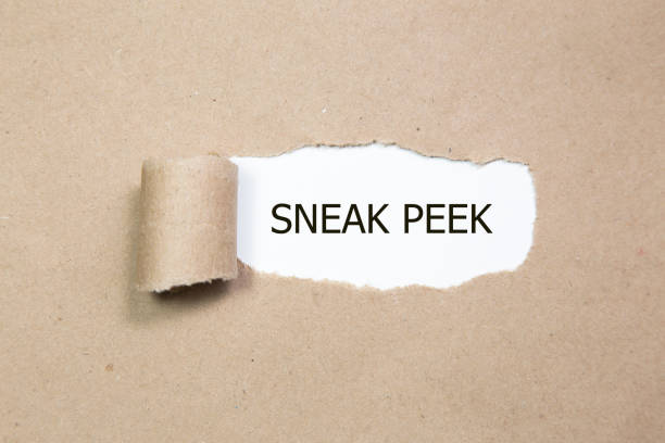 The phrase Sneak Peek appearing behind torn yellow paper. stock photo