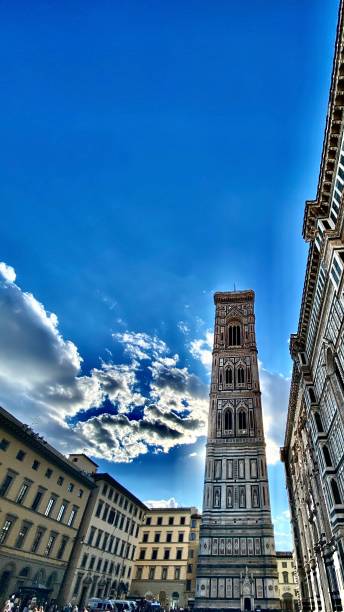 the piazza del duomo; standing in the gothic shadow of giotto’s campanile (bell tower) beside the cattedrale di santa maria del fiore (florence cathedral). stock photo