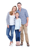 Studio shot of a mother, father and daughter smiling at the camera against a white background