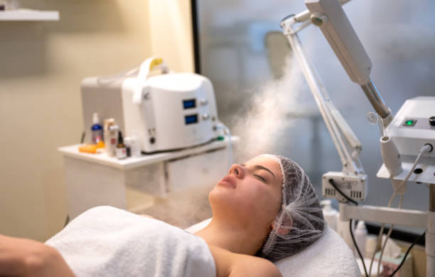 The procedure of steaming the skin of the face of young woman before cleaning the skin in a beauty salon. stock photo