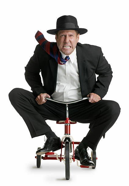The Rat Race A businessman riding a tricycle symbolizing the rat race of the business world.For more businessman photos click: adult tricycle stock pictures, royalty-free photos & images