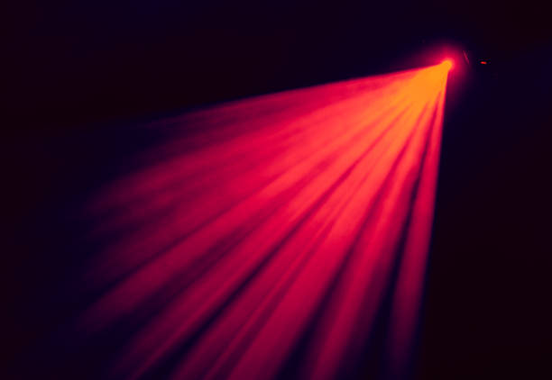 la luce rossa dai riflettori attraverso il fumo a teatro durante lo spettacolo. apparecchi di illuminazione - red spotlight foto e immagini stock