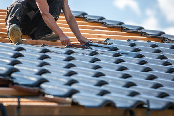 The roof coverer laying a new roof on the new building, bungalow, construction concept stock photo