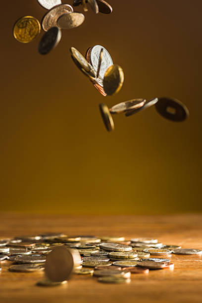 The silver and golden coins and falling coins on wooden table...