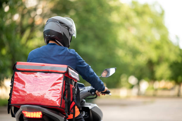 The staff prepares the delivery box on the motorcycle for delivery to customers. stock photo