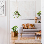 istock The stylish boho interior of open room in cozy apartment with design furnitures and elegant personal accessories. Template. Home decor. Honey yellow concept. 1352456080
