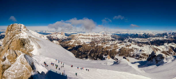 在義大利多洛米人的陽光明媚的日子裡, 馬莫拉達的山頂上有滑雪者準備好的和背景的塞拉山 - marmolada 個照片及圖片檔