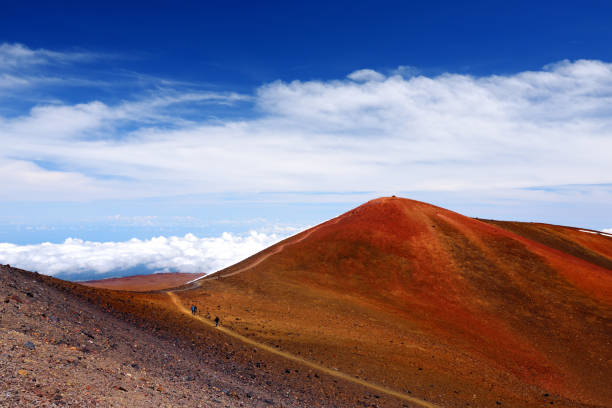 The summit of Mauna Kea, a dormant volcano on the island of Hawaii, USA The summit of Mauna Kea, a dormant volcano on the island of Hawaii. Stunningly beautiful red stone peak hovering above clouds, the highest point in the state of Hawaii, USA. mauna kea stock pictures, royalty-free photos & images