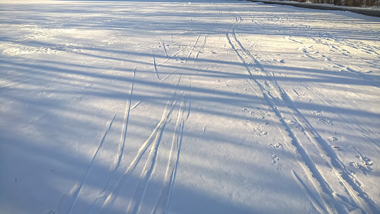 Ski trail in the park. The sun reflects off the snow.