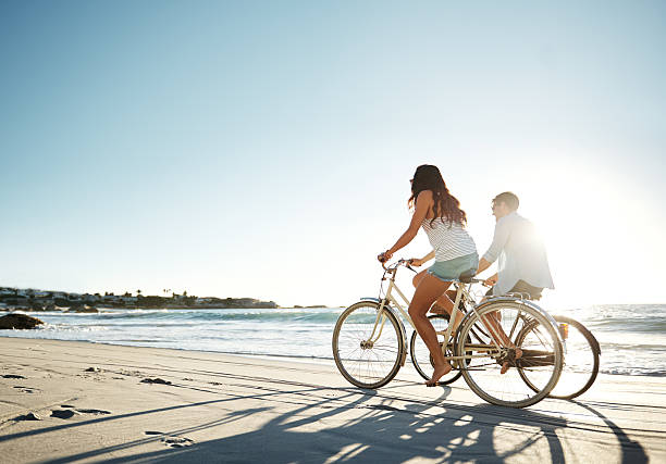 the sun will never set on their love - fietsen strand stockfoto's en -beelden